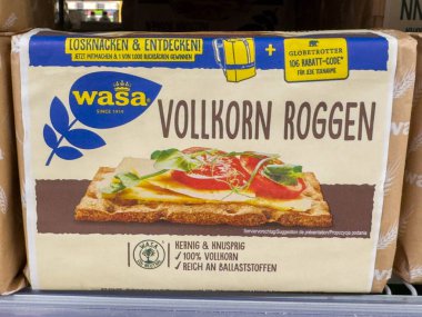 Bleiburg, Avusturya - 19 Eylül 2025: Wasa Vollkorn Roggen süpermarket rafında gevrek ekmek paketi, besleyici atıştırmalık tercihleri ve marka tarihini vurguluyor
