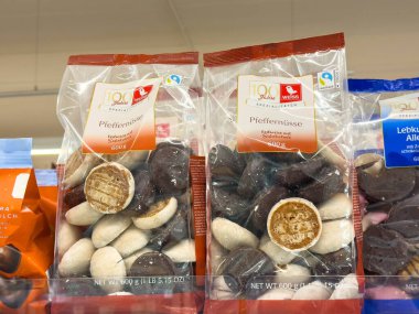 Bleiburg, Avusturya - 19 Eylül 2025: Pfeffernusse kurabiyeleri mağaza rafında açık poşetlerde, eşsiz dokularını ve şenlikli renklerini vurgulayarak