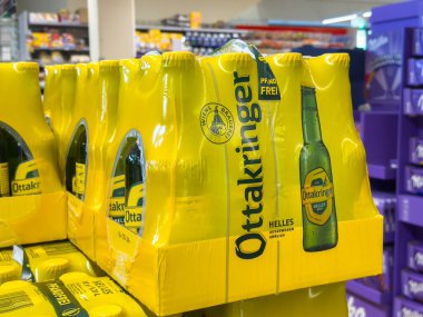 Bleiburg, Avusturya - 19 Eylül 2025: Ottakringer Helles birası, açık sarı ambalajı ve davetkar tasarımı ile perakende satış ortamında sergilenmektedir.