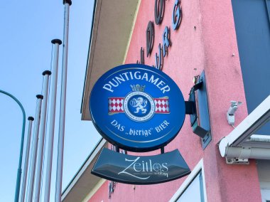 Bleiburg, Avusturya - 19 Eylül 2025: Pembe binanın dış tarafındaki Puntigamer bira tabelası, markayı vurguluyor ve müşteriler için davetkar bir ortam yaratıyor