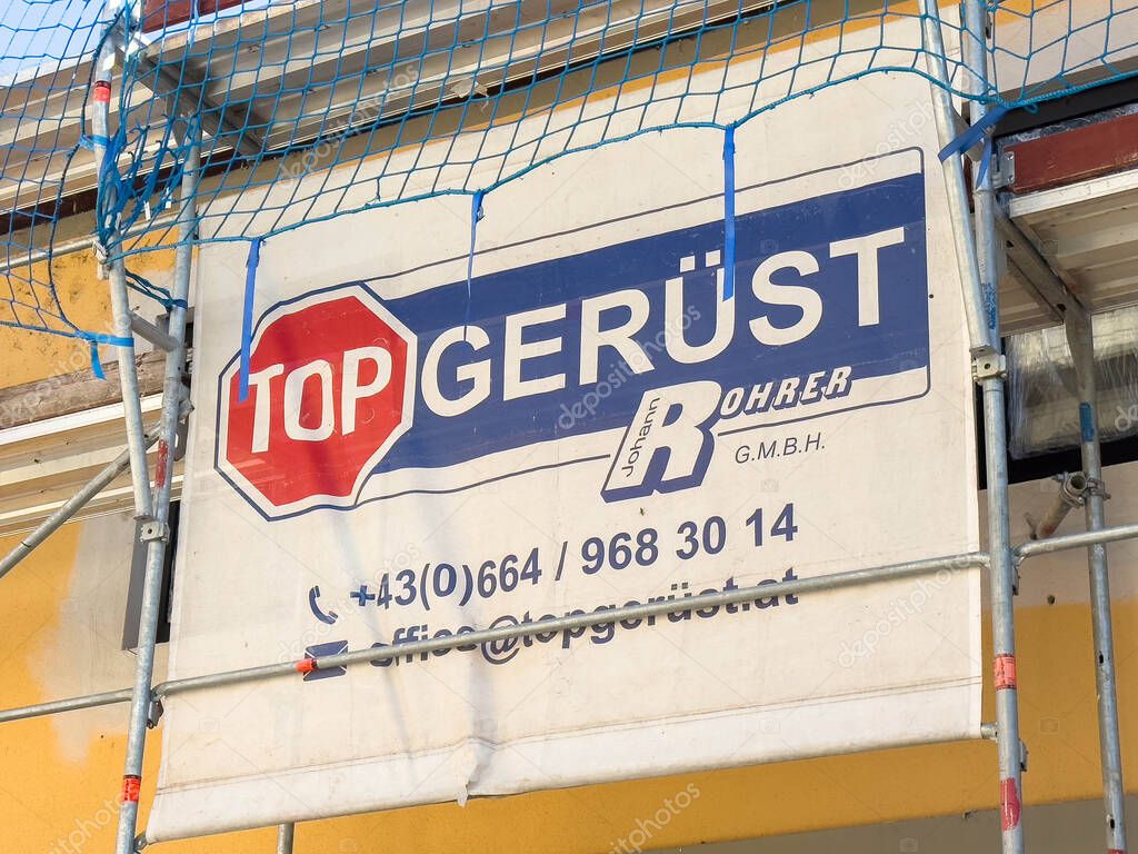 Bleiburg, Austria - September 19, 2025: Top Gerust sign on scaffolding, featuring contact details and branding for construction services in urban setting
