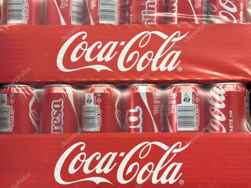 Bleiburg, Austria - September 19, 2025: Stacked Coca-Cola cans in bright red packaging, highlighting the famous beverage brand and its refreshing appeal