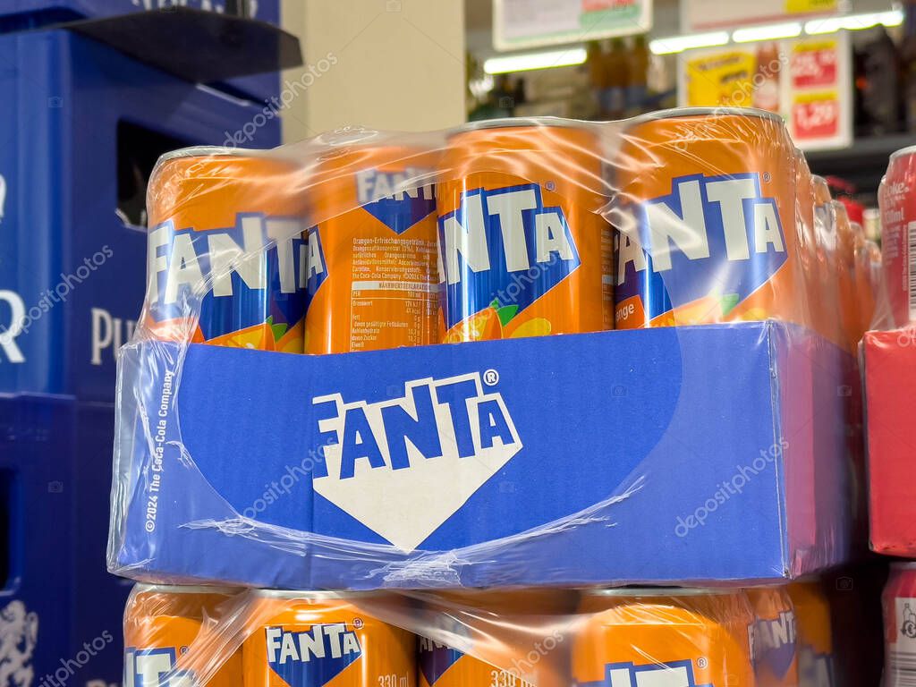 Bleiburg, Austria - September 19, 2025: Fanta soda cans are neatly stacked in a retail environment, highlighting the bright orange color and branding