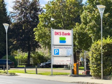 Sankt Veit Ad Glan, Avusturya - 17 Eylül 2025: BKS Bank tabelası dışarıda park alanı ve yeşillikle görülüyor, bankanın varlığını vurguluyor