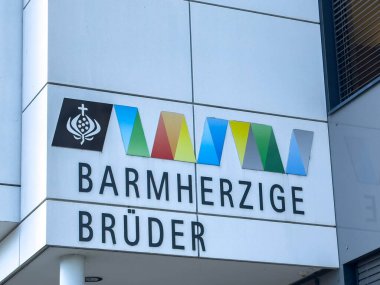 Sankt Veit Ad Glan, Avusturya - 17 Eylül 2025: Bina cephesinde Barmherzige Bruder tabelası, renkli logo ve şık mimari tasarım