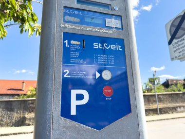 Sankt Veit Ad Glan, Avusturya - 17 Eylül 2025: St. Veit parkmetresi ödeme talimatlarını ve seçenekleri mavi gökyüzü ile parlak şehir ortamında gösteriyor