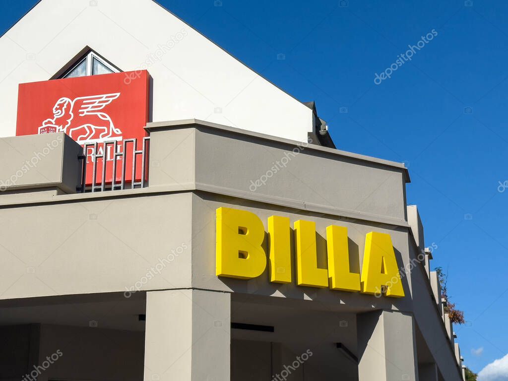Sankt Veit Ad Glan, Austria - September 17, 2025: BILLA supermarket features vibrant yellow signage and red logo, set against a clear blue sky, highlighting contemporary design elements