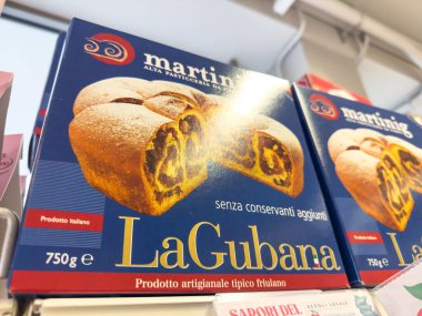 Gemona, İtalya - 24 Eylül 2025: LaGubana pasta kutusu zengin dolgu ve zanaat tasarımı içeriyor, bir fırın rafında güzelce sunuluyor, müşterileri eğlenmeye davet ediyor