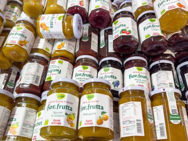 Gemona, İtalya - 24 Eylül 2025: Bir bakkalda Fior Frutta meyve reçelleri kavanozları düzenlenir, farklı tatlar ve renkli etiketler vurgulanır