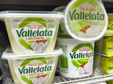 Gemona, İtalya - 24 Eylül 2025: Vallelata peynir ürünleri bir süpermarket rafında taze ve kremsi dokusunu canlı markalaştırarak düzenli bir şekilde düzenlenmiştir.