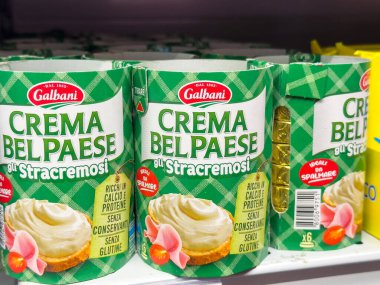 Gemona, İtalya - 24 Eylül 2025: Galbani Crema Belpaese Stracremosi peynir serpme kutuları renkli ambalaj ve ürün cazibesini ön plana çıkaran bir süpermarket rafına dizilmiştir