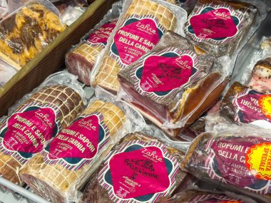 Gemona, İtalya - 24 Eylül 2025: Kasap dükkanında rengarenk etiketli paket etler, yemek sevenler için kalite ve çeşitlilik vurgulanıyor