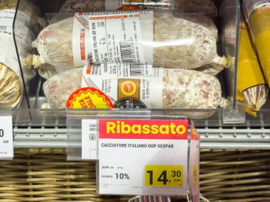 Gemona, İtalya - 24 Eylül 2025: İtalyan Cacciatore salamı markette fiyat etiketi ve yerel lezzetleri ön plana çıkaran promosyon etiketleriyle belirgin bir şekilde sergilenmektedir