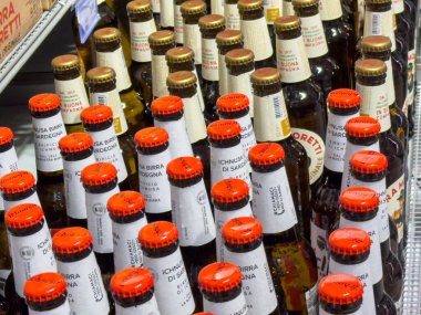 Gemona, İtalya - 24 Eylül 2025: Ichnusa bira şişeleri bir süpermarket rafında sergilenmekte olup, mevcut İtalyan el yapımı biraların çeşitliliğini vurgulamaktadır