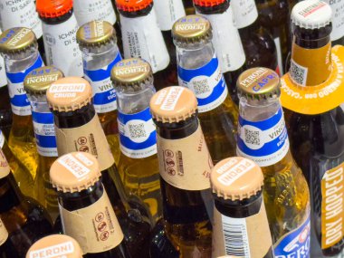 Gemona, İtalya - 24 Eylül 2025: Farklı marka ve kapaklı çeşitli bira şişeleri bir araya getirilerek renkli ve davetkar bir içecek gösterisi oluşturuldu