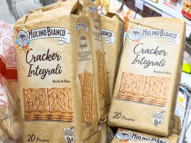 Gemona, İtalya - 24 Eylül 2025: Mulino Bianco Cracker Integrali ambalajı açık bir şekilde bir süpermarkette sergilenmekte ve sağlıklı alışverişçiler için besleyici aperatif seçenekleri vurguluyor