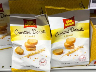 Gemona, İtalya - 24 Eylül 2025: Süpermarket rafında San Carlo Crostini Dorati Klasik çerez poşetleri, çıtır desen ve çekici ambalaj tasarımı