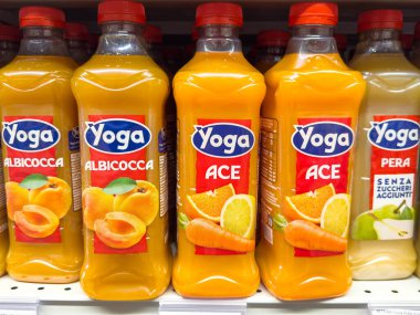 Gemona, İtalya - 24 Eylül 2025: Süpermarket raflarında sergilenen Yoga meyve suyu şişeleri, parlak renkler ve içecek seçeneklerini canlandırmak için cazip etiketler
