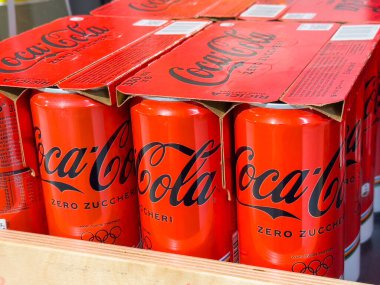 Gemona, İtalya - 24 Eylül 2025: Coca-Cola Sıfır Şeker kutuları, ünlü logo ve Olimpiyat tasarım unsurları vurgulanarak kırmızı paketleme içinde düzenli olarak düzenlenir
