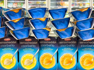 Gemona, İtalya - 24 Eylül 2025: Vibrant Dolfin gelato sorbetto kutuları markette istiflenmiştir, renkli ambalajlar ve cazip tatlar ön plana çıkarılmıştır