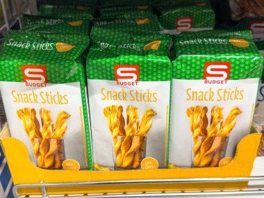 Gemona, İtalya - 24 Eylül 2025: Bütçe abur cuburları açık bir süpermarket rafında, parlak ambalajlı ve abur cubur severler için cezbedici görseller içeren düzenlenmiştir