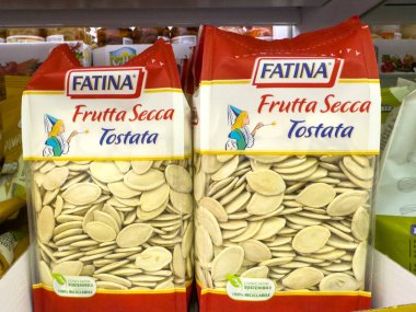 Gemona, İtalya - 24 Eylül 2025: Fatina Frutta Secca Tostata balkabağı tohumu paketleri süpermarket rafında, canlı renkleri ve sağlıklı atıştırmalık seçenekleri vurguluyor