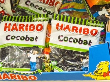 Gemona, İtalya - 24 Eylül 2025: Haribo Cocobat şekerleme paketleri neşeli tasarımlar ve parlak renklerin yer aldığı canlı bir rafta düzenlenmiştir