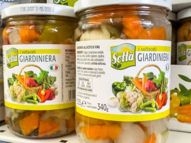 Gemona, İtalya - 24 Eylül 2025: Sott 'it Giardiniera turşulu sebze kavanozları bir rafa dizilir, renkli içerikleri ve çekici ambalajları vurgulanır