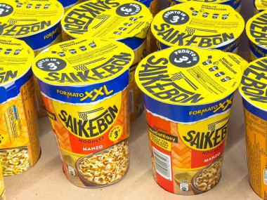 Gemona, İtalya - 24 Eylül 2025: Parlak sarı fincanlarda Saikebon erişteleri çeşitli tatlar ve uygun yemek seçenekleri vurgulanarak düzgünce düzenlenmiştir