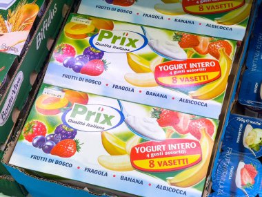 Gemona, İtalya - 24 Eylül 2025: Prix yoğurt ambalajı muzlu ve karışık böğürtlenli çeşitli tatları çekici grafiklerle açık bir market vitrininde sergiliyor
