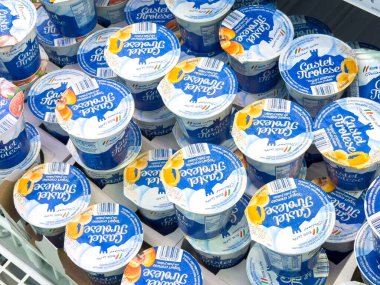Gemona, İtalya - 24 Eylül 2025: Bir süpermarket dondurucusunda istiflenmiş yoğurt bardakları canlı tatlar ve sağlıklı atıştırmalık seçenekleri için çekici paketler sergiliyor