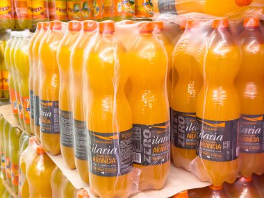 Gemona, İtalya - 24 Eylül 2025: Ilaria Arancia portakallı sodası şişeleri süpermarket rafındaki plastik ambalajlarda sergileniyor, canlı renkler ve ferahlatıcı seçenekler vurgulanıyor