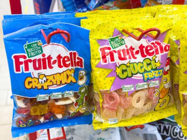 Gemona, İtalya - 24 Eylül 2025: Çılgın Karışık ve Fruzz aromalı parlak renkli şeker torbaları perakende satış ortamında belirgin bir şekilde sergilendi