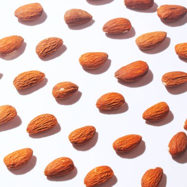 Üstten görünüm badem badem desenli arka plan beyaz arka plan üzerinde ayarlayın. Fındık bileşimi. Dekorasyon, sağlıklı beslenme ve gıda arka plan hakkında kavramları. Düz yatıyordu, en iyi görünüm. En az kavramı.