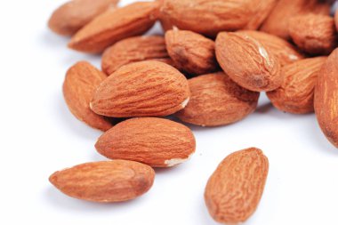 Badem izole. Beyaz zemin üzerine fındık grubudur. Badem tohumları toplama yığını. Sığ derinlik-in tarla. Düz yatıyordu, en iyi görünümü.