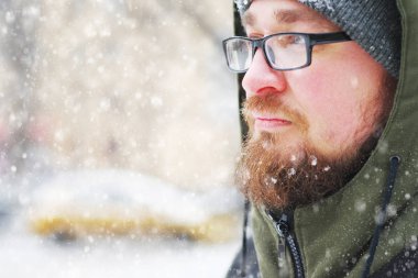 Bir kar fırtınası ormanın içinde donup kalan ev genç sakallı adam portresi. Yüz, sakal, bıyık ve gözlük frost ile kaplı.