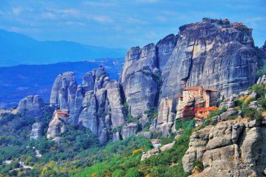 Manastır Meteora Yunanistan. Yaz panoramik manzara çarpıcı. dağlar ve epik mavi gökyüzü bulutlar Unesco miras listesi nesnesiyle karşı yeşil orman. Havadan görünümü büyük Meteor ve Rousanou Manastırı