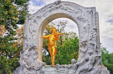 Johann Strauss monument in Stadtpark, Vienna, Austria. Golden statue of great Austrian composer, Waltz King, playing violin clipart