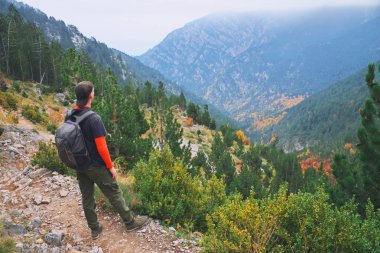 Günbatımı sis, yaz dağlarda uçurumun tepesinde duran ve doğanın manzarayı genç backpacker adam. Olimpos Dağı, Yunanistan, Avrupa, sonbahar sonbahar. Macera yalnız yaşam tarzı kavramı seyahat.