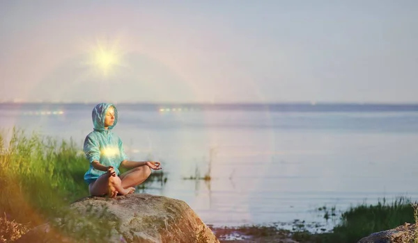 Hermosa mujer pacífica se sienta en una pose de medio loto practicando meditación de yoga, cielo azul de verano, chakra brillante, los ojos cerrados calma. Ejercicio de energía Kundalini. Espíritu humano, concepto de curación de personas —  Fotos de Stock