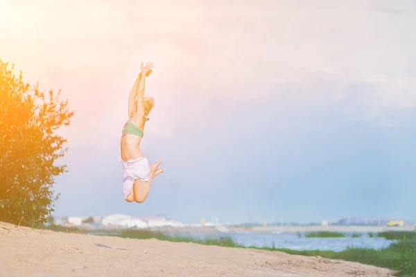 Giovane donna felice che salta sulla spiaggia. Bella festa ragazza dan — Foto Stock