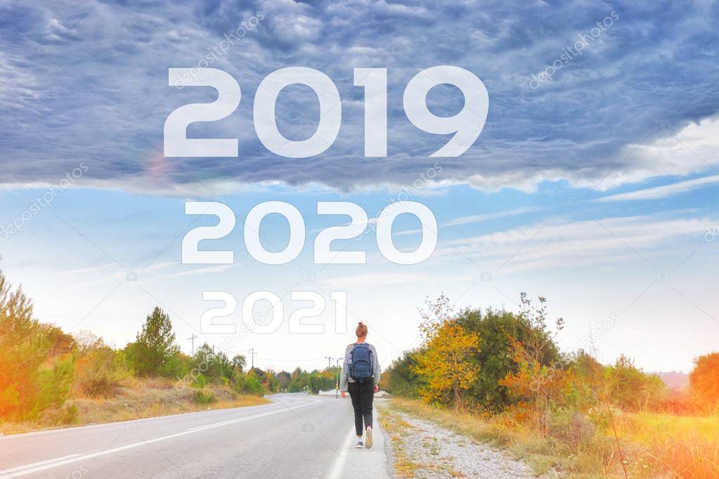 Woman traveler walking alone along road to goals 2020 2021 new y