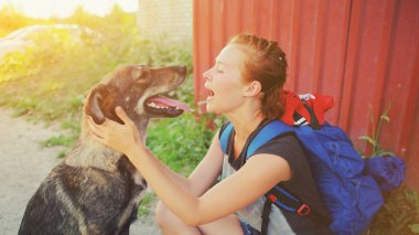 Sırt çantası öpüşme köpek açık havada Mutlu evcil hayvan ve çekici kız eğlenceli Pozitif insan arkadaş duygular, yüz ifadesi, duygular sevgi insanlar ve hayvan arasında oynarken portre genç hipster kadın.