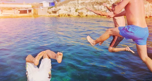 Skupina šťastných šílenských lidí, kteří se baví skákat v mořské vodě — Stock fotografie