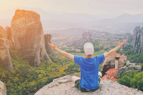 Hombre levantarse de la mano sentado en la cima de la montaña disfrutando de la paz mo —  Fotos de Stock