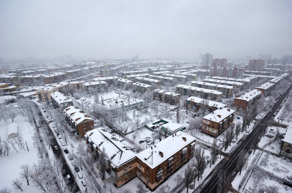 The aerial View of residential district in dusky winter day.View over the city rooftops with sunlight and snow.Moderns buildings at Industrial uptown, residential neighbourhood. Kiev,Ukraine