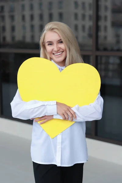 Usmívající se mladá žena drží žlutý talíř v rukou — Stock fotografie