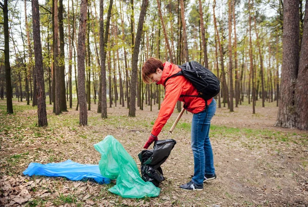 Mujer voluntaria recogiendo basura en el parque — Foto de Stock