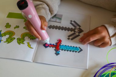 Pembe 3D kalem. Çocuk erimiş plastikle bir kılıç çekiyor. Bilim, yeni teknolojiler, çocuk eğitimi. Yüksek kalite fotoğraf