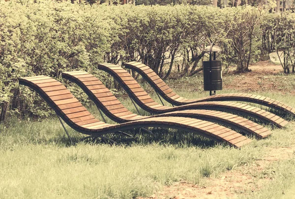 Espreguiçadeiras de primavera para relaxar em um parque público - tonificação de imagem — Fotografia de Stock